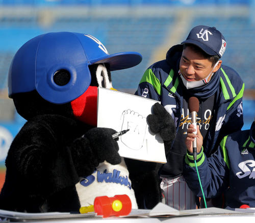 2021年12月5日　「FA」と書かれたフリップを手にするつば九郎と笑顔でトークする中村悠平