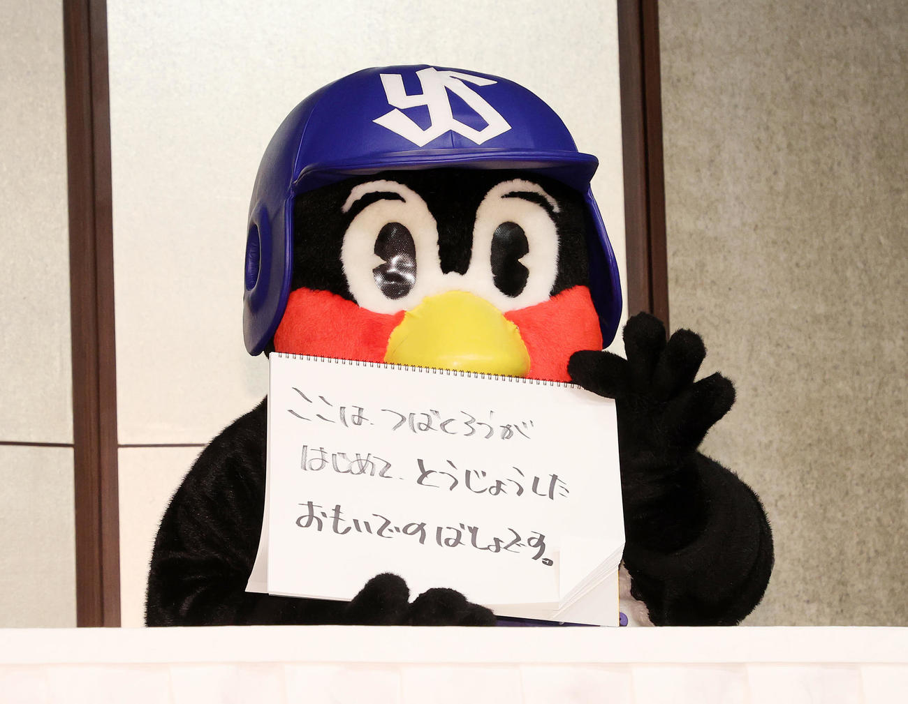 つば九郎2000試合出場フライング会見　「ここは　つばくろうが、はじめてとうじょうした　おもいでのばしょです」と書いたヤクルトのマスコットつば九郎＝2022年8月5日　