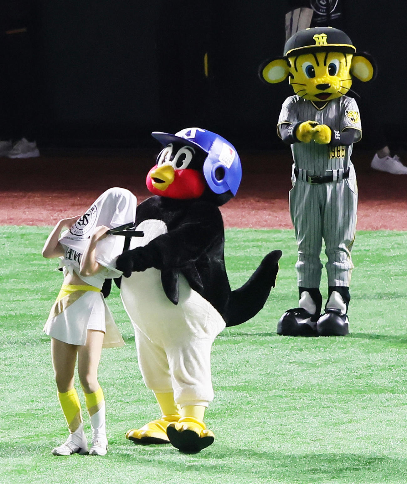2022年7月26日、オールスター第1戦、ソフトバンクのチアに無理やりヤクルトのTシャツを着させようとするつば九郎（中央）。右は阪神トラッキー