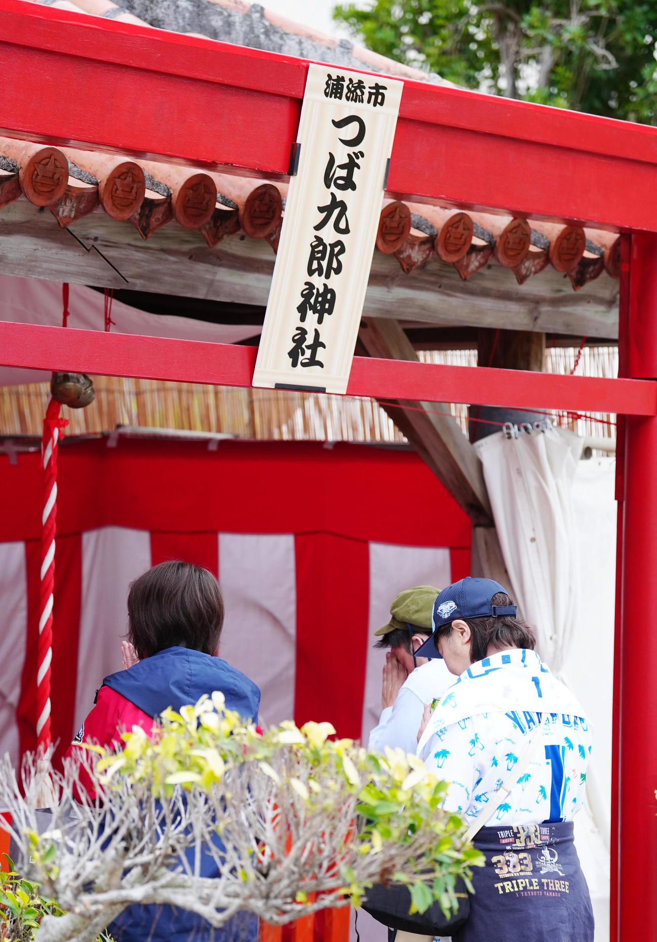 沖縄・浦添市にあるつば九郎神社で手を合わせるファン（撮影・江口和貴）