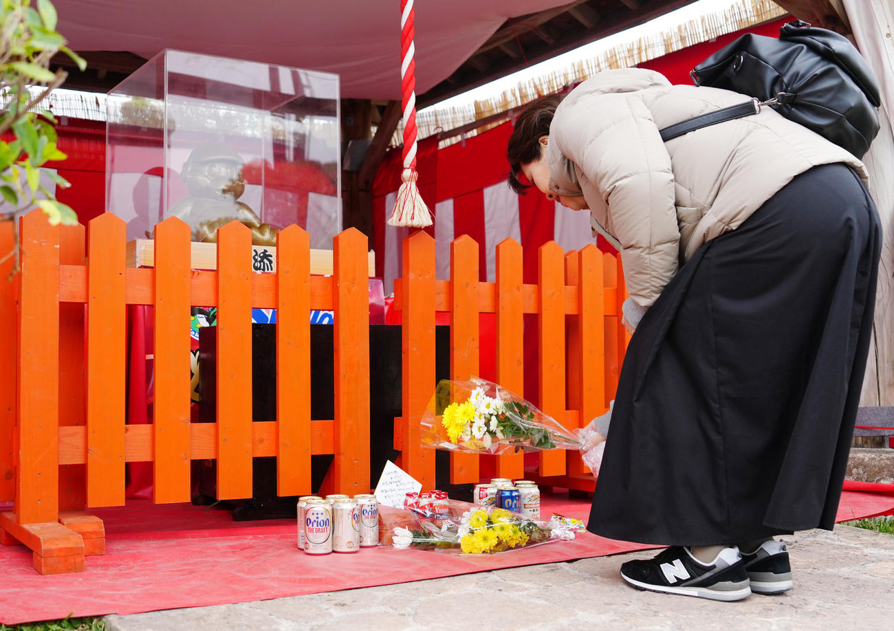 沖縄・浦添市にあるつば九郎神社で献花するファン（撮影・江口和貴）