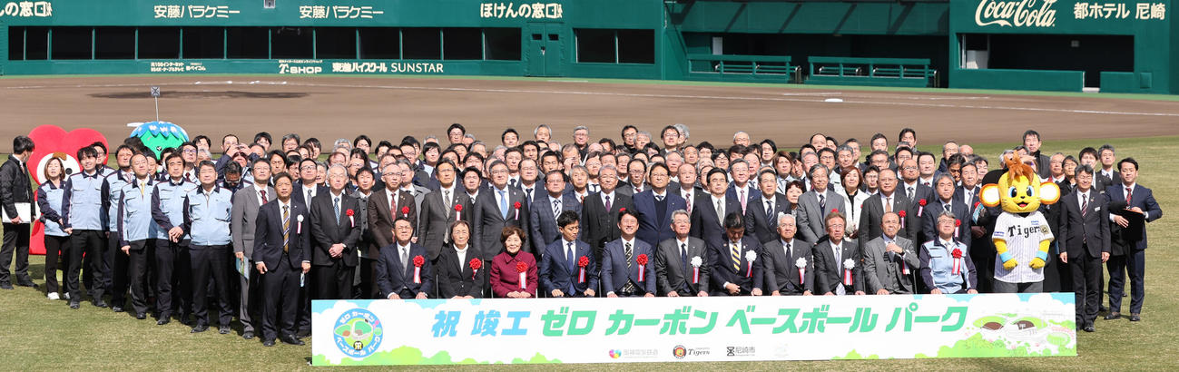 阪神2軍の新本拠地となる日鉄鋼板SGLスタジアム尼崎が完成し記念写真に納まる関係者。着席の前列右から2人目が阪神岡田オーナー付き顧問（撮影・西尾就之）