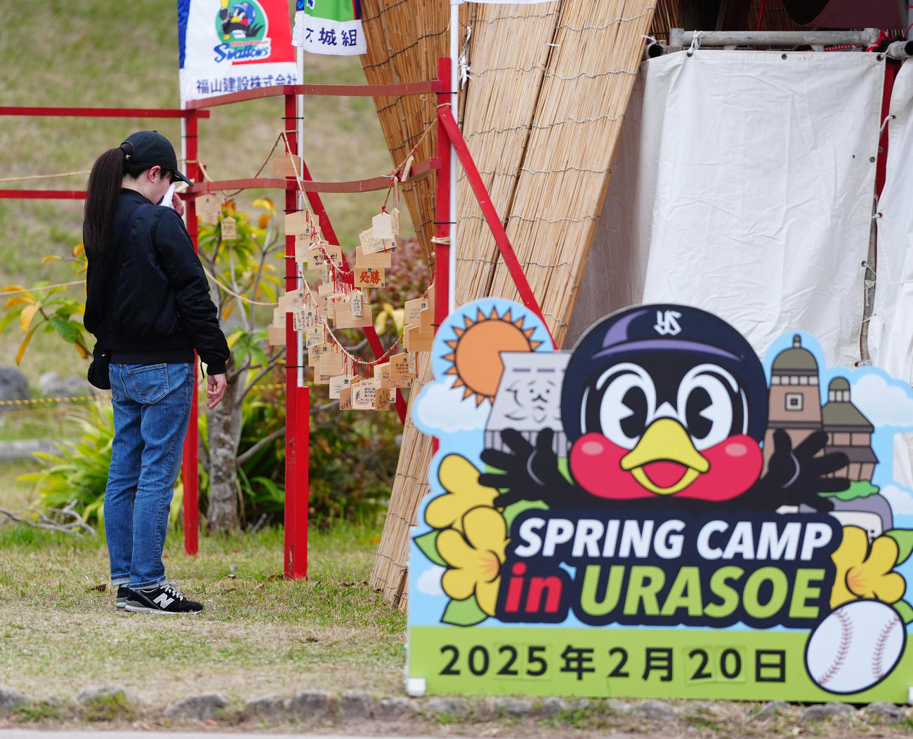 沖縄・浦添市にあるつば九郎神社にかけられる絵馬を見つめ、涙を流すファン（撮影・江口和貴）