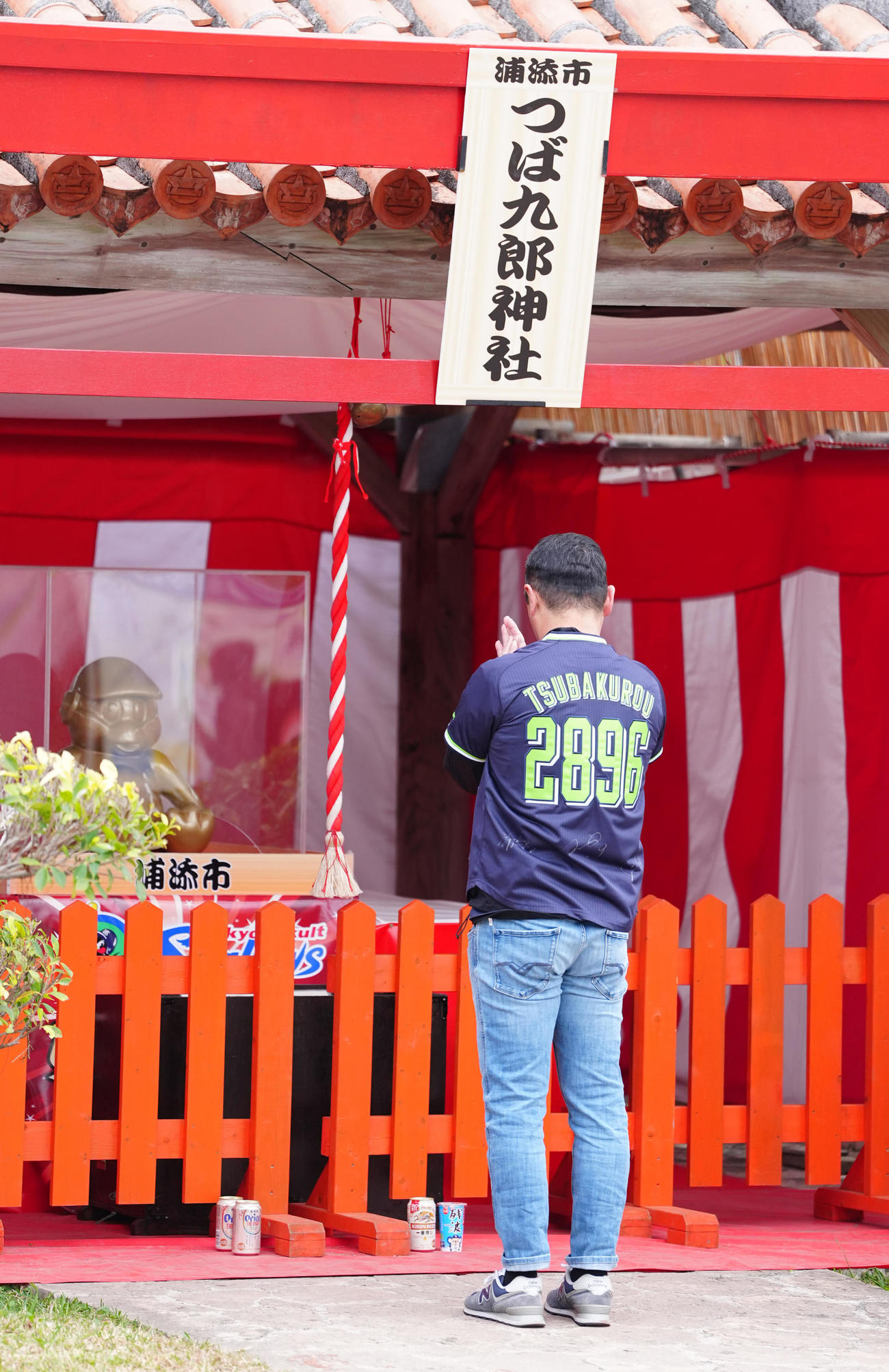 沖縄・浦添市にあるつば九郎神社で手を合わせるファン（撮影・江口和貴）