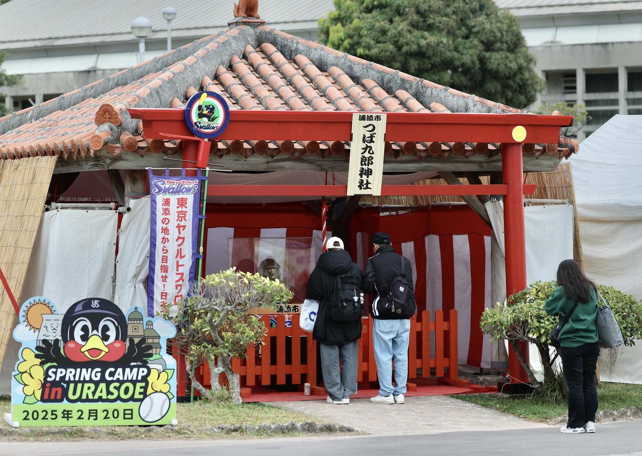 つば九郎神社で手を合わせるファン（撮影・河田真司）