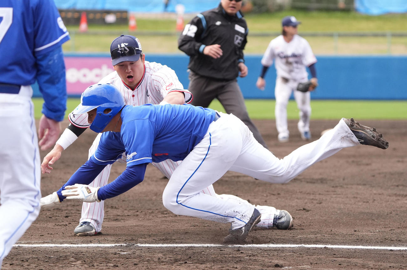 ヤクルト対中日　2回裏中日1死一、三塁、三塁走者・石伊が飛び出しタッチする村上（左）（撮影・森本幸一）