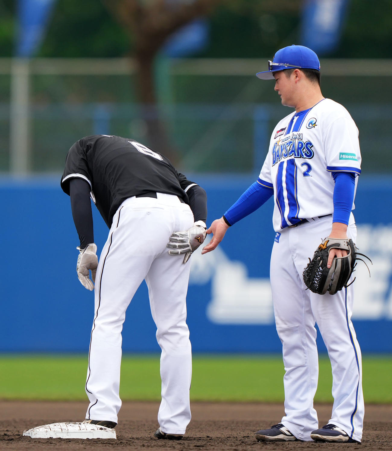 DeNA対ロッテ　2回表ロッテ2死一、二塁、けん制球が尻に当たり痛がる西川。右は心配する牧（撮影・横山健太）