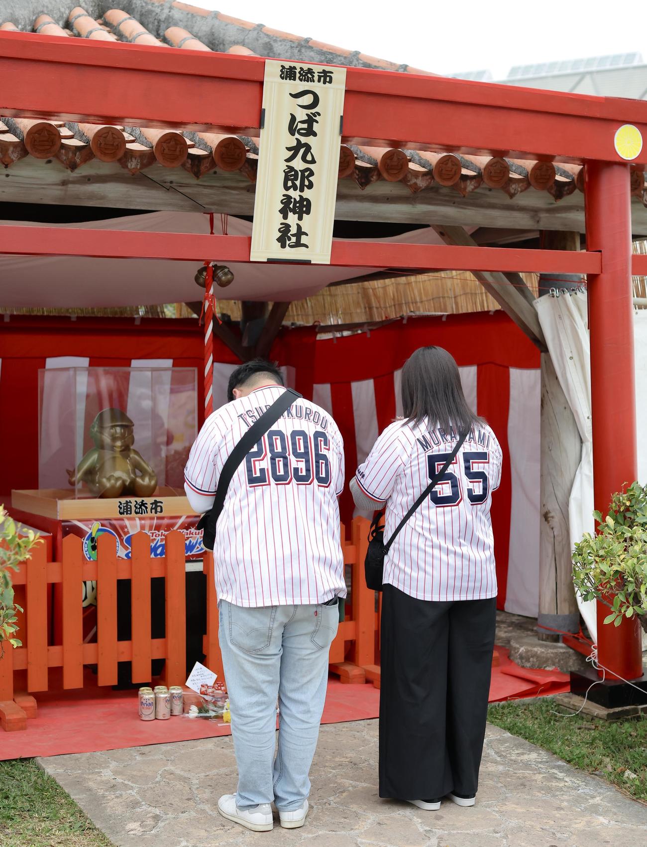 つば九郎神社で手を合わせるファン（撮影・河田真司）