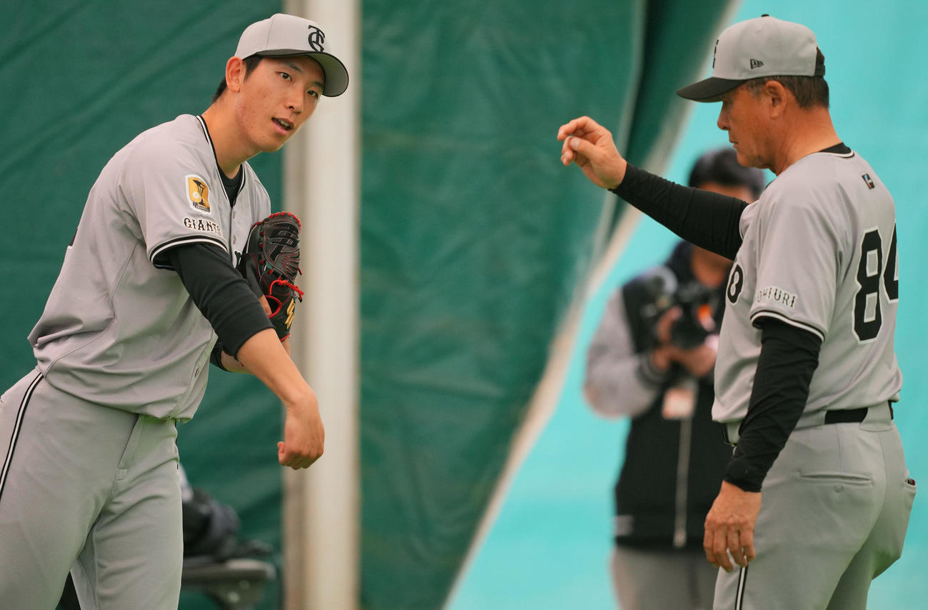 ブルペン投球後、巨人戸郷（左）は久保巡回投手コーチの指導を受ける（撮影・垰建太）