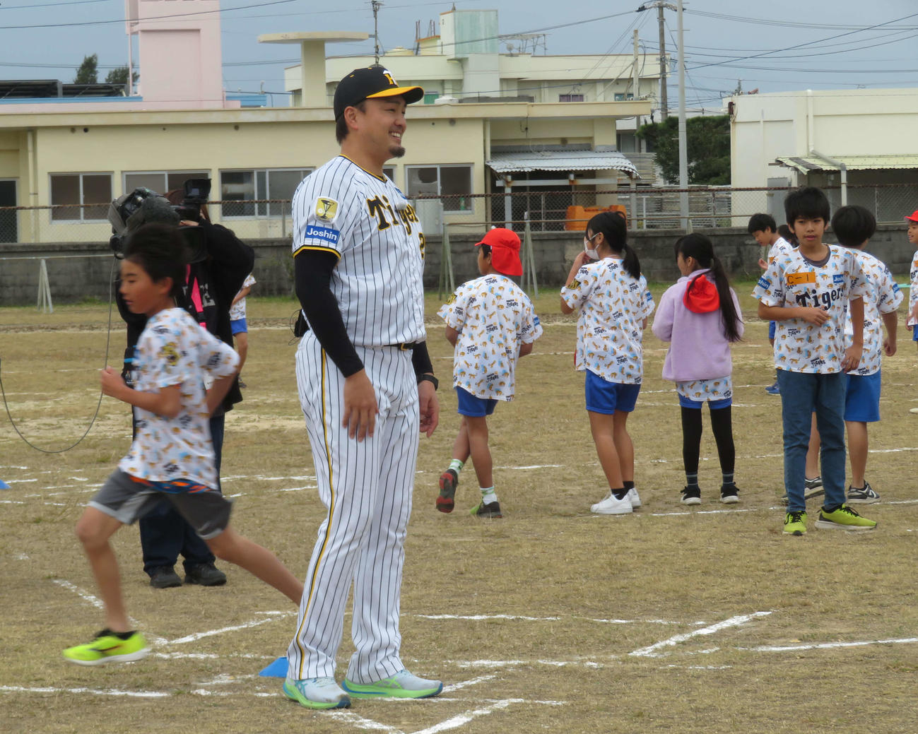 ゲストティーチャーとして子どもに指導し笑顔を見せる阪神秋山拓巳ベースボールアンバサダー（撮影・磯綾乃）