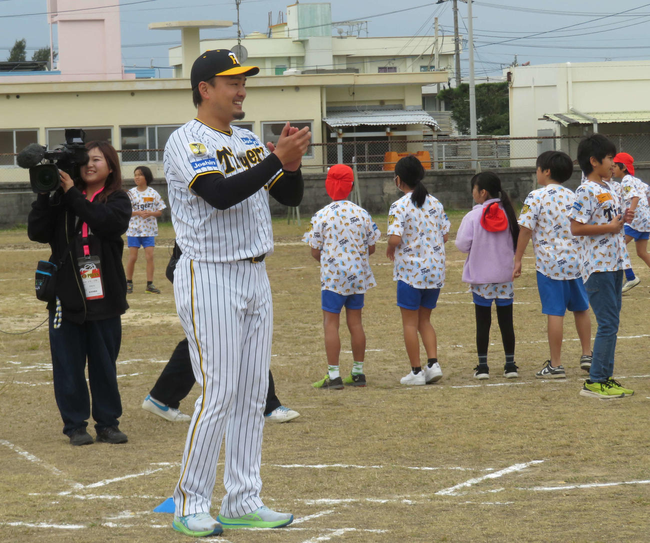 ゲストティーチャーとして子どもに指導し笑顔を見せる阪神秋山ベースボールアンバサダー（撮影・磯綾乃）