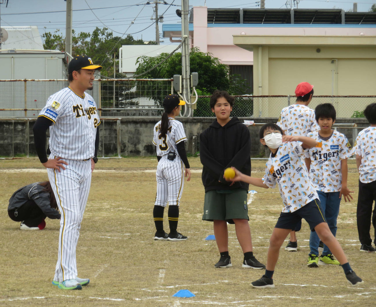 ゲストティーチャーとして子どもに指導し笑顔を見せる阪神秋山ベースボールアンバサダー（撮影・磯綾乃）