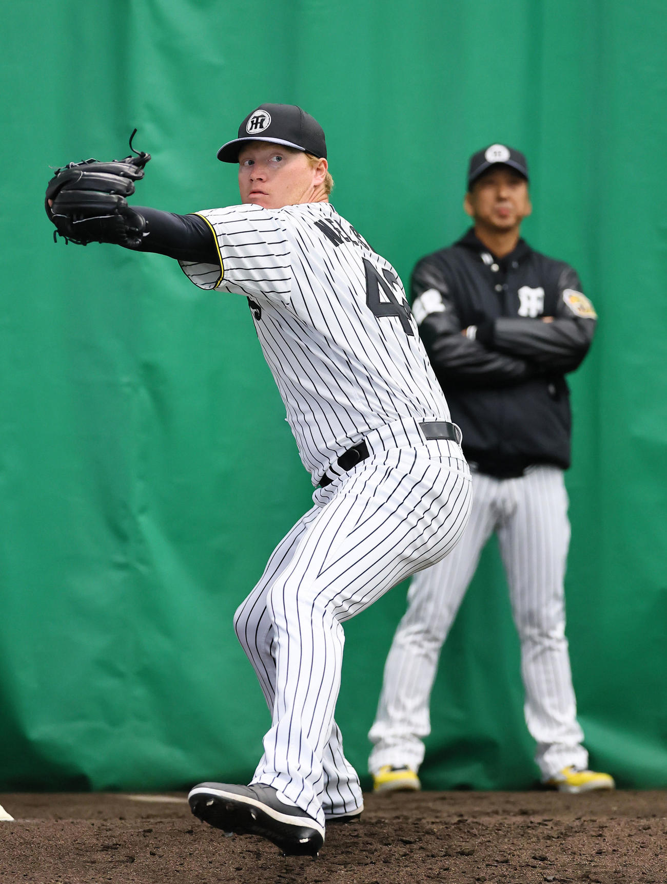 ブルペンで藤川監督が見つめる中、投球練習をするネルソン（撮影・藤尾明華）