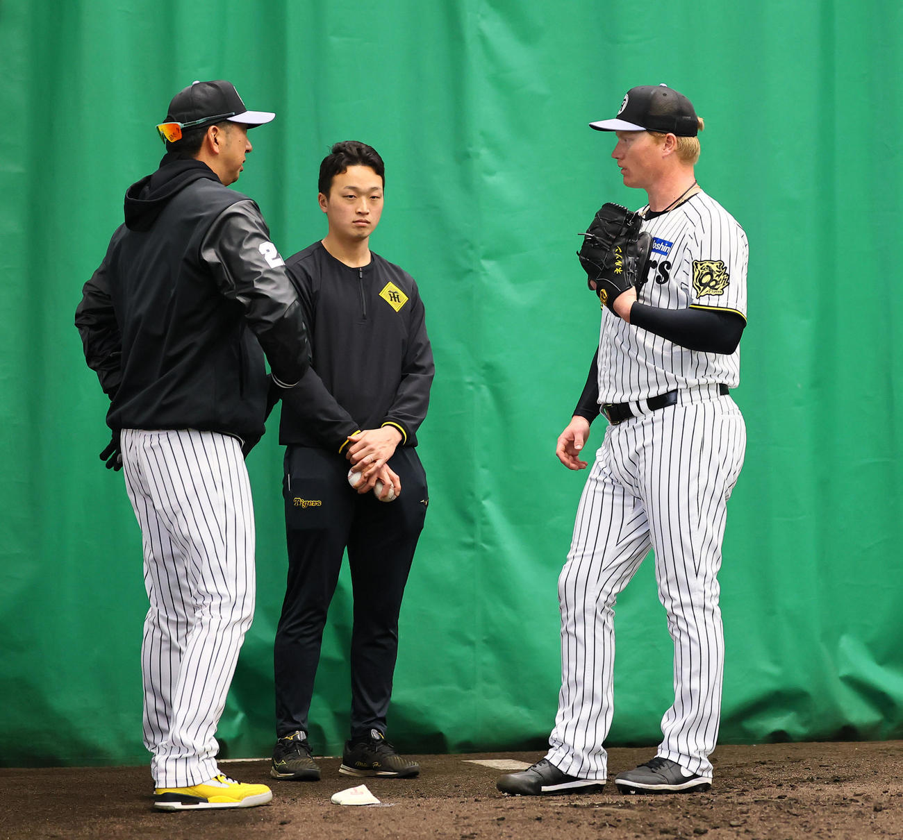 ブルペンで藤川監督（左）に指導を受けるネルソン（撮影・藤尾明華）