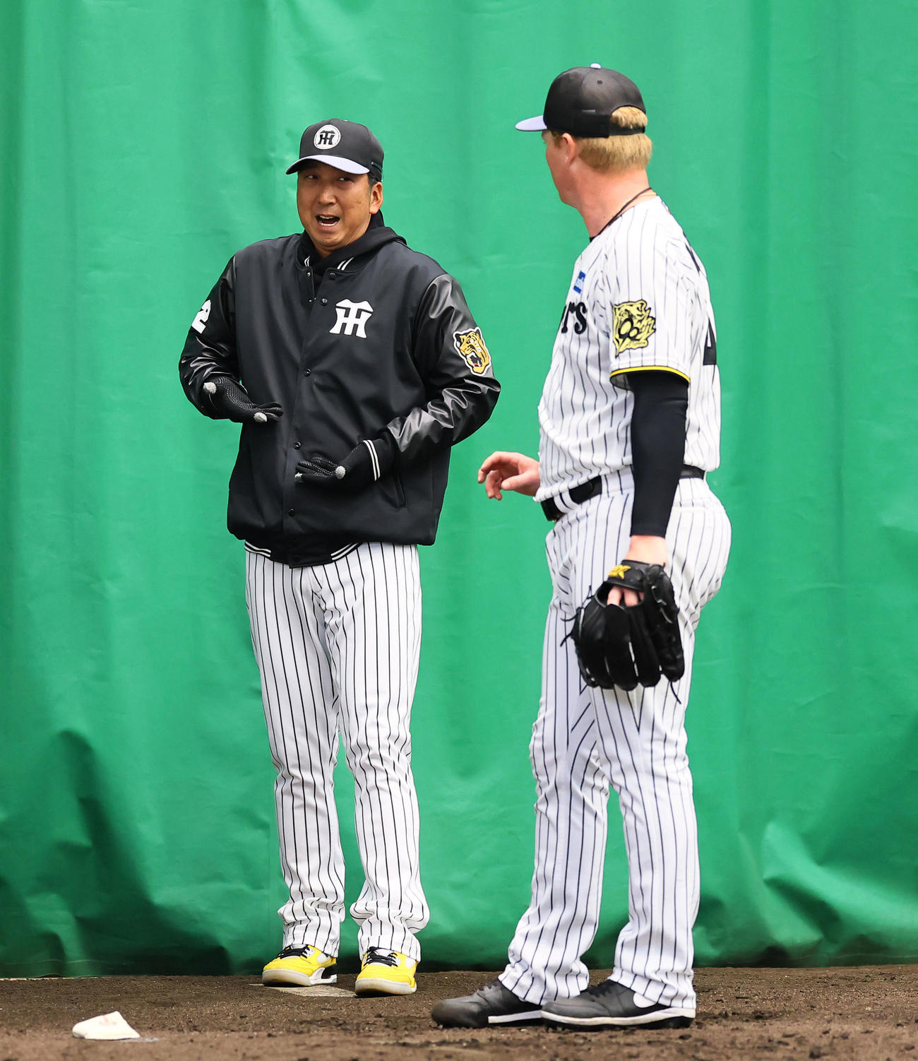 ブルペンでネルソン（右）にアドバイスする藤川監督（撮影・藤尾明華）