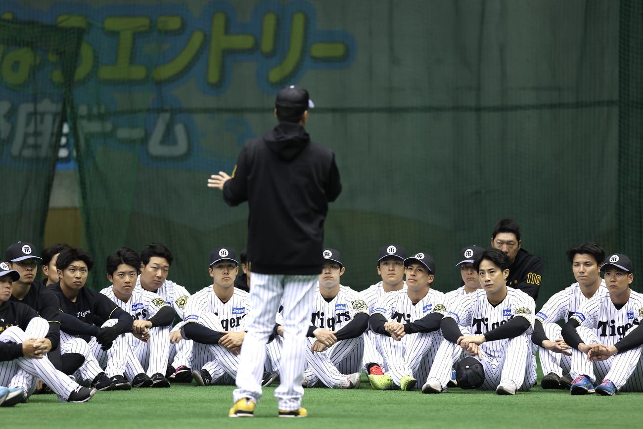 練習前、阪神藤川監督（手前）の話を座って聞く選手たち（撮影・前田充）