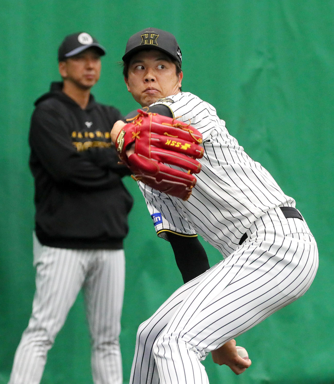 ブルペンで投球する阪神才木。奥は藤川監督（撮影・上山淳一）