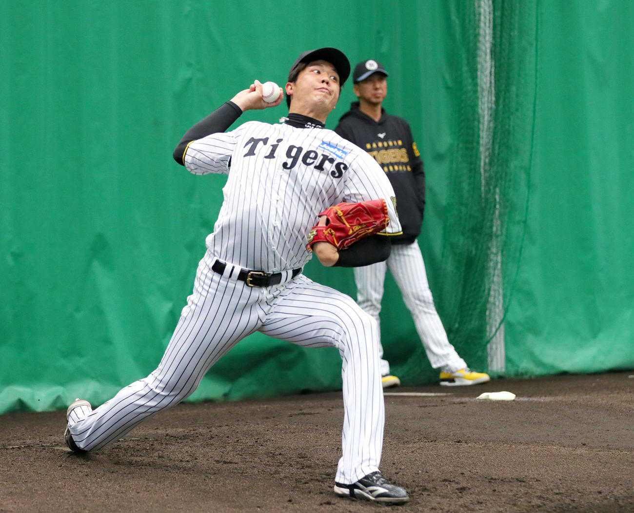 ブルペンで投球する阪神才木。奥は藤川監督（撮影・上山淳一）