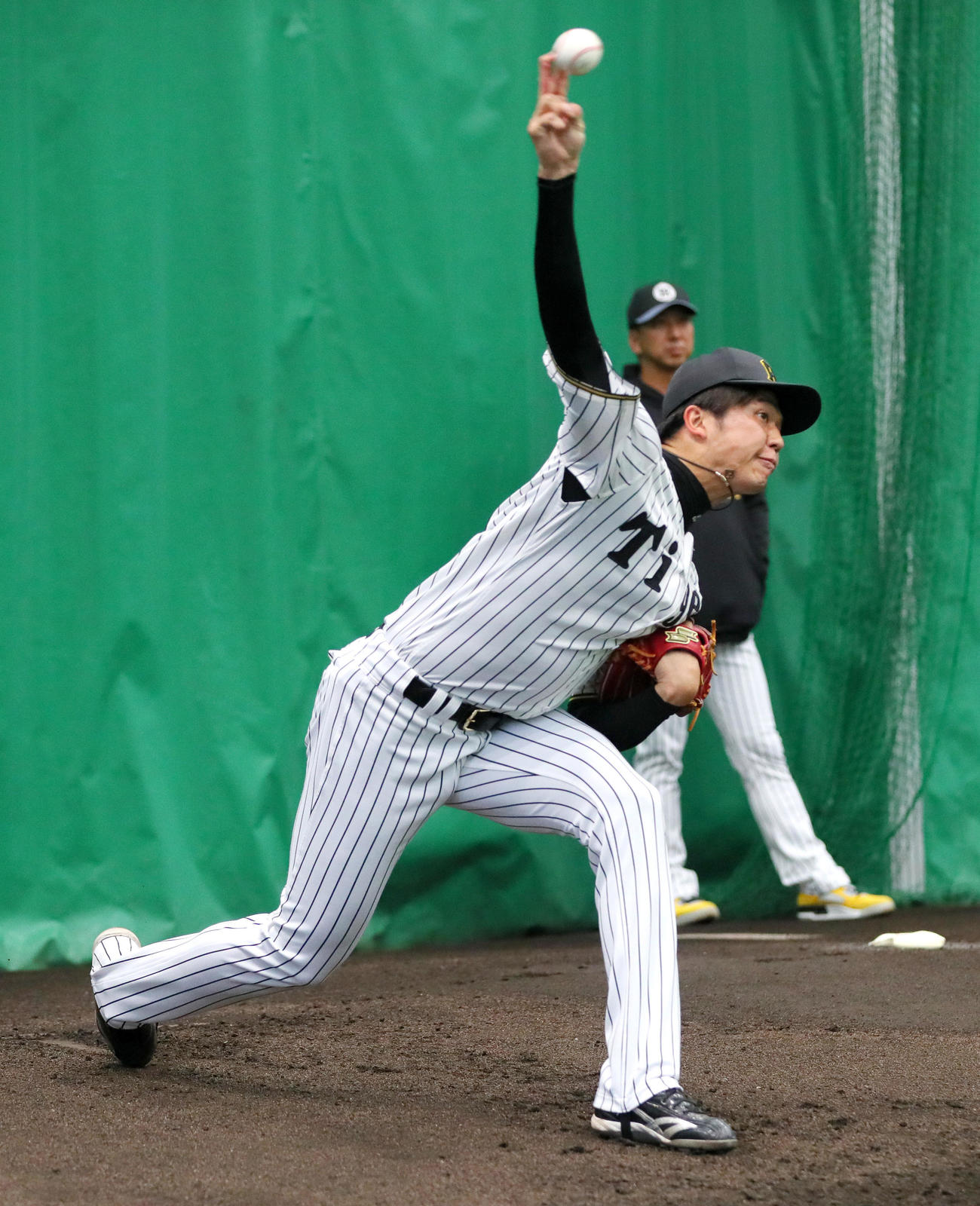 ブルペンで投球する阪神才木。奥は藤川監督（撮影・上山淳一）