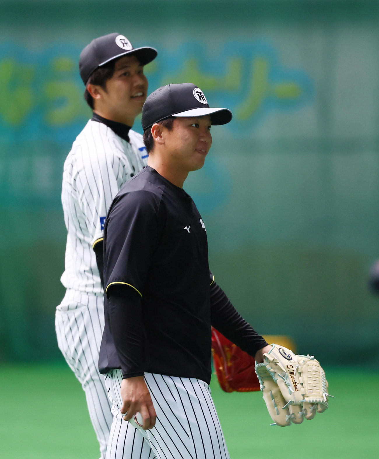 停電で照明が消えた中、キャッチボールを終えた阪神村上（右）と才木（撮影・藤尾明華）