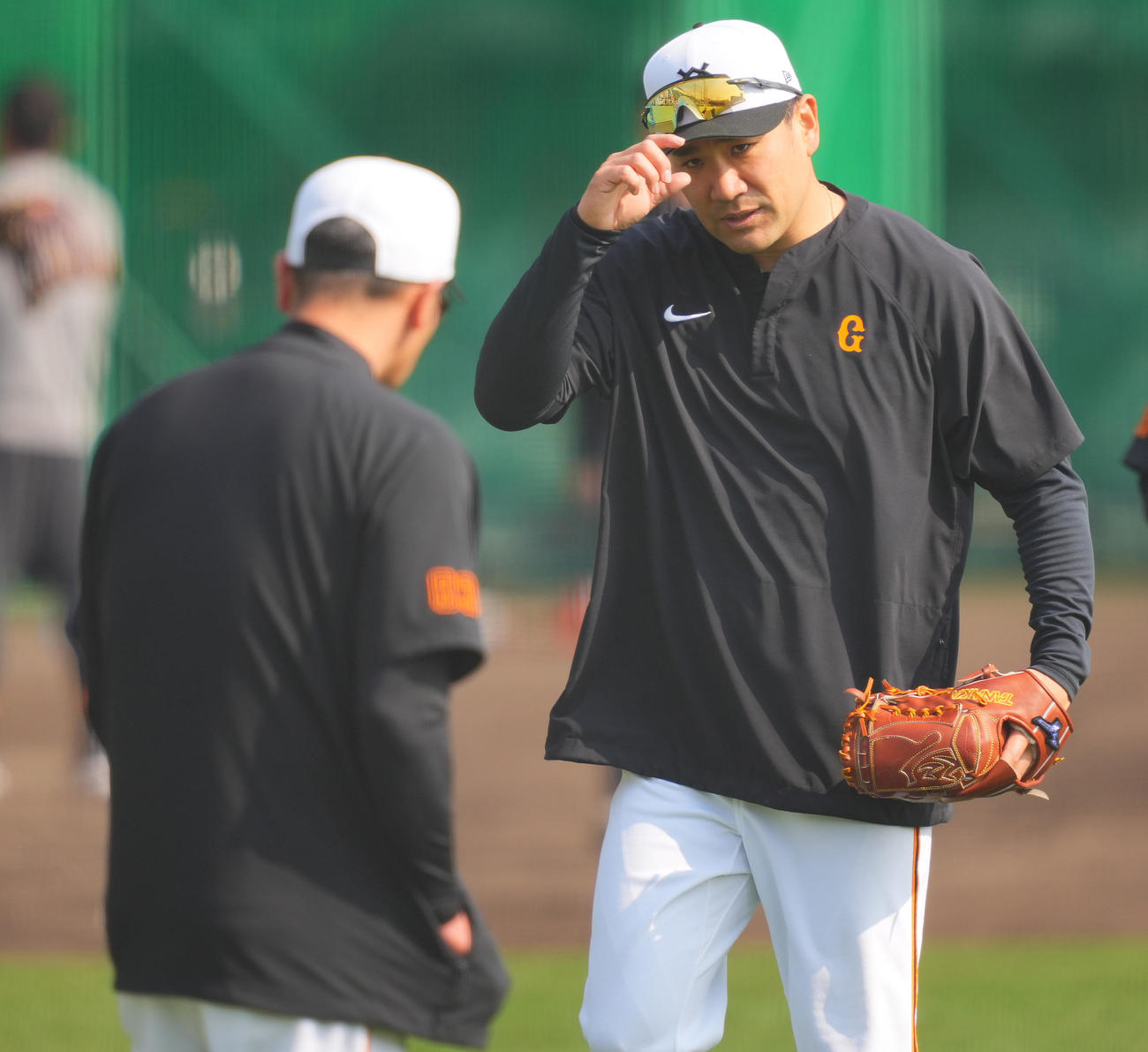 練習中、巨人阿部監督（手前）にあいさつする田中将（2025年2月撮影）