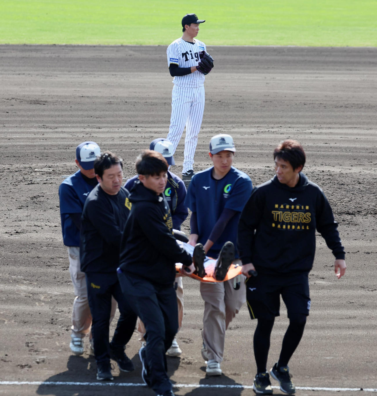 阪神対ハンファ　7回表ハンファ1死二塁、マウンドで気持ちを切らさずキャッチボールする湯浅と手前は担架で運ばれる負傷交代の戸井（撮影・加藤哉）