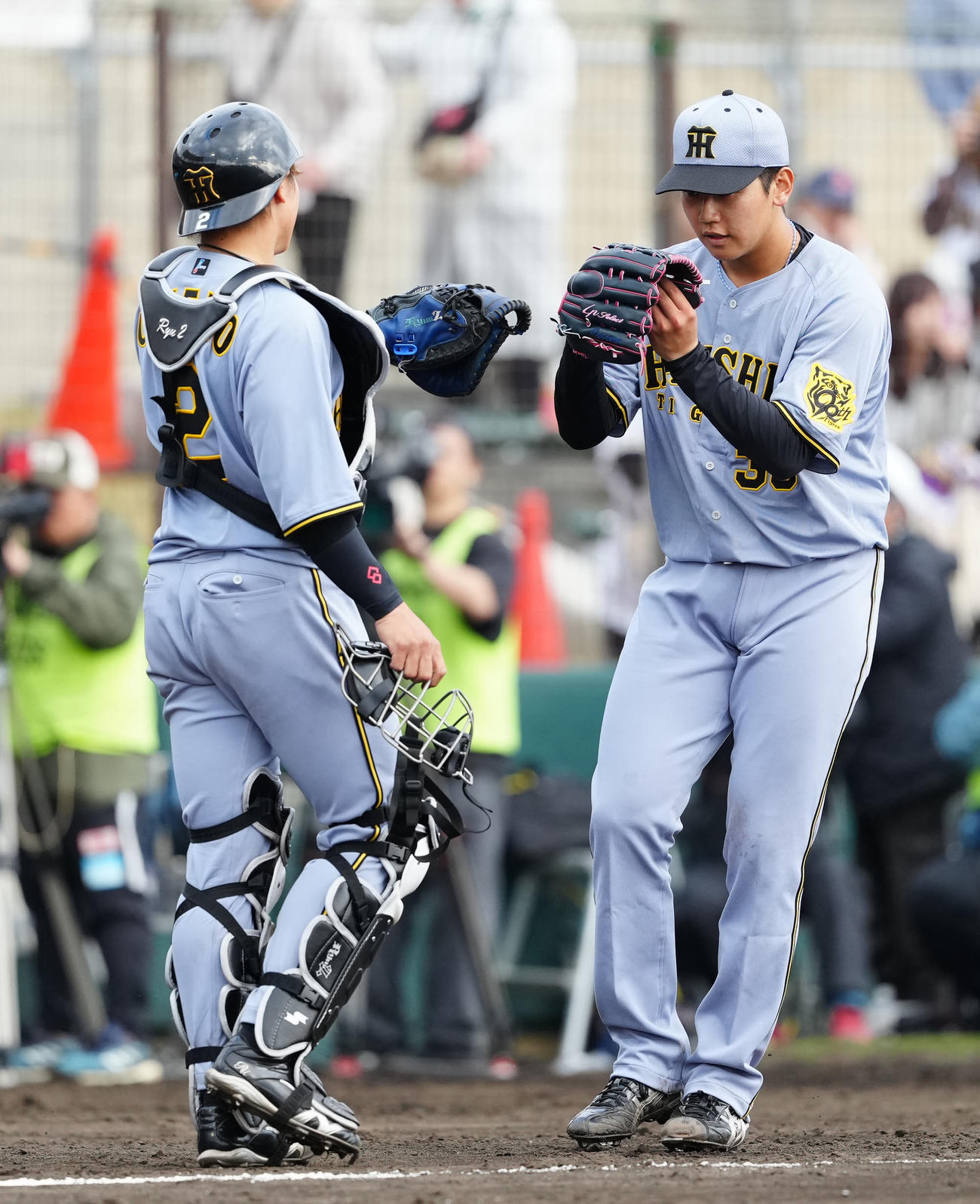 楽天対阪神　試合後、阪神捕手梅野（左）とタッチを交わす6番手の門別（撮影・江口和貴）