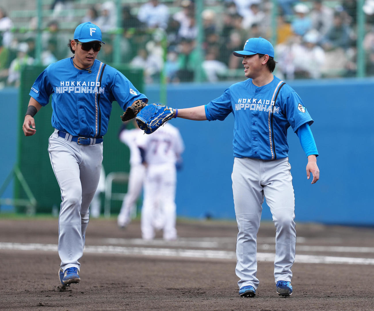 ヤクルト対日本ハム　8回裏ヤクルトの攻撃を無失点に抑えた河野（右）は野村とタッチを交わす（撮影・足立雅史）
