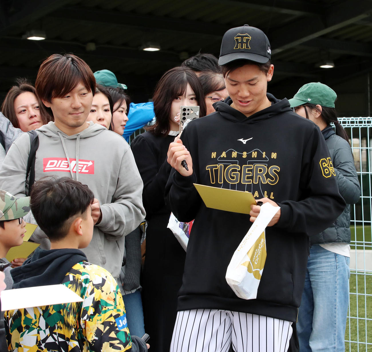 阪神対ハンファ　試合後、ファンにサインする湯浅（撮影・加藤哉）