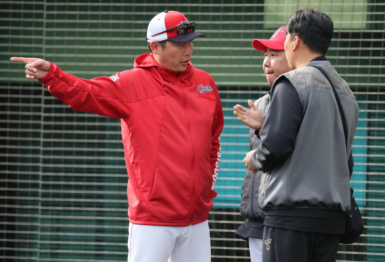 試合終了後、KIAのイ・ボムホ監督（中央）と話し合う広島新井監督（撮影・加藤孝規）