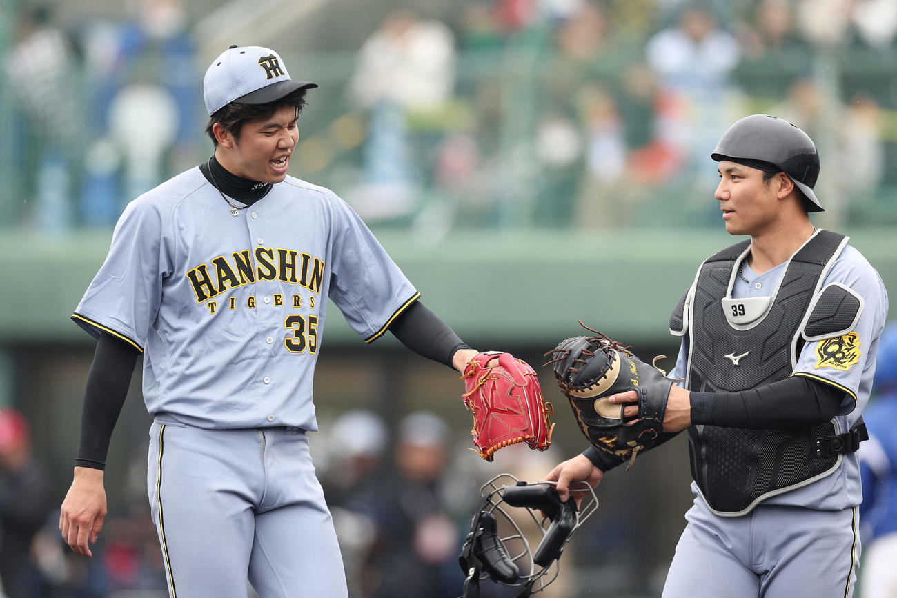 中日対阪神　2回裏を投げ終え、厳しい表情を見せながら阪神栄枝（右）とタッチを交わす才木（撮影・前田充）