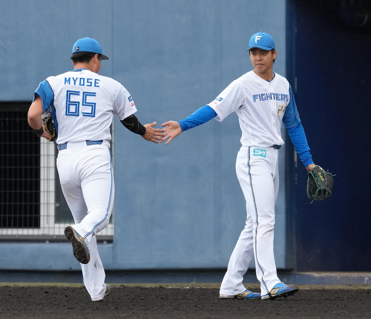 日本ハム対楽天　7回表楽天の攻撃を3者凡退に抑えた日本ハム杉浦（右）は明瀬とタッチを交わす（撮影・足立雅史）