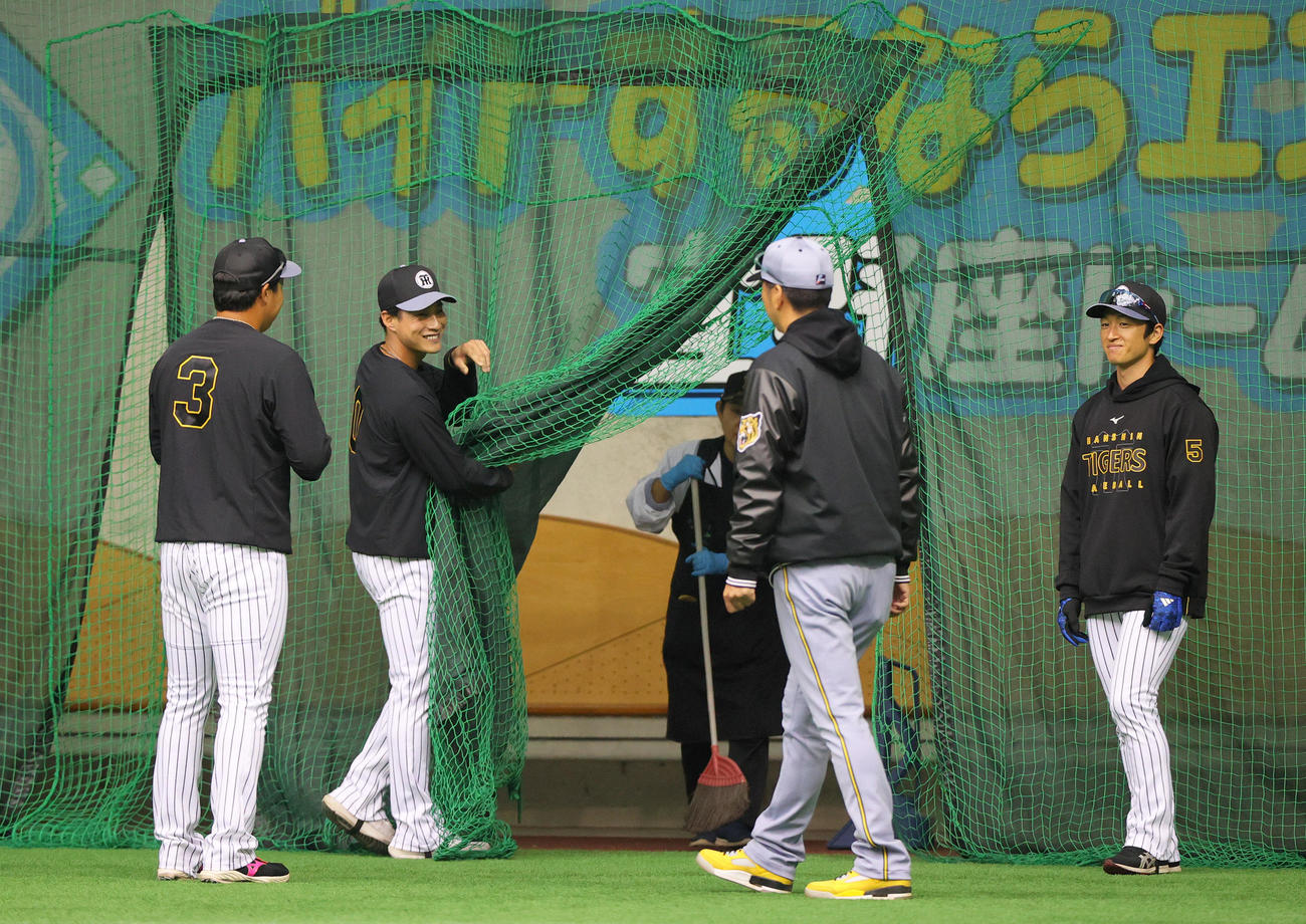 阪神木浪（左から2人目）はネットを持ち上げ藤川監督（同3人目）に行き先を譲ろうとする。左は大山、右は近本（撮影・上山淳一）