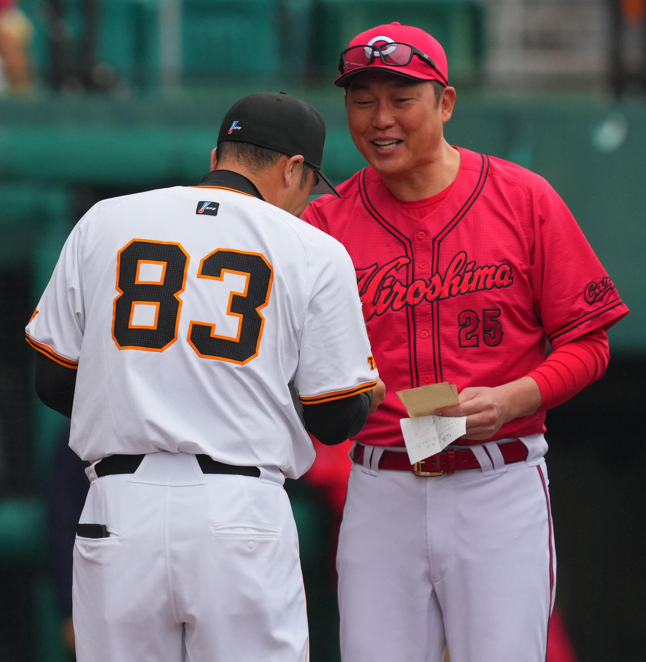 巨人対広島　メンバー表交換の時に広島新井監督（右）に球団のグッズを渡す巨人阿部監督（撮影・垰建太）