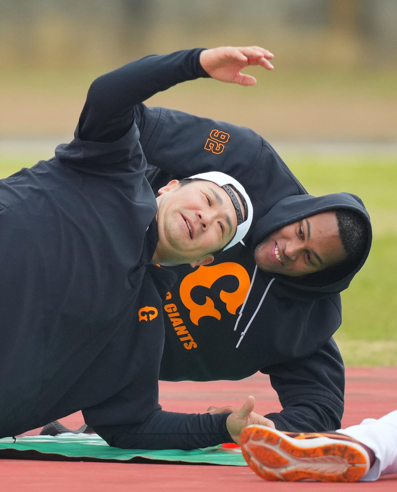 体幹トレーニング中にじゃれ合う巨人田中将（左）とマルティネス（撮影・垰建太）