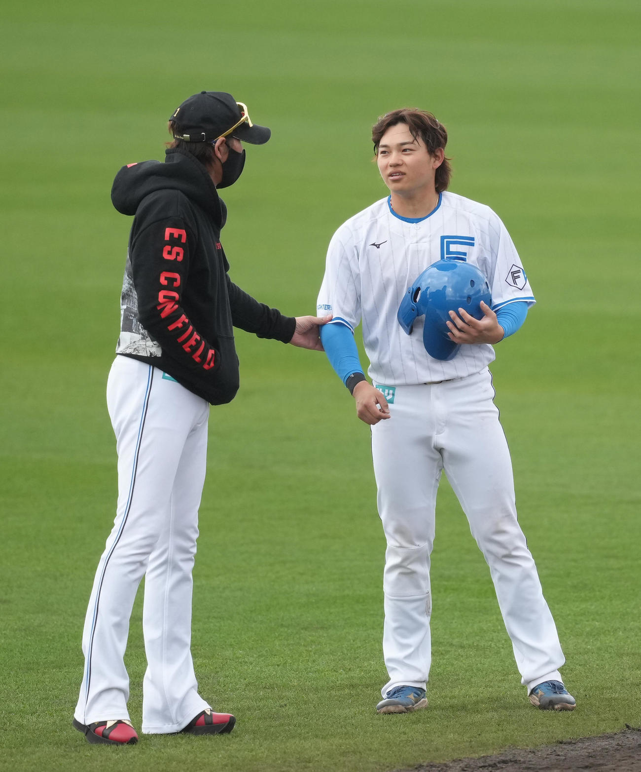日本ハム田宮（右）の手を取り話す新庄監督（撮影・足立雅史）