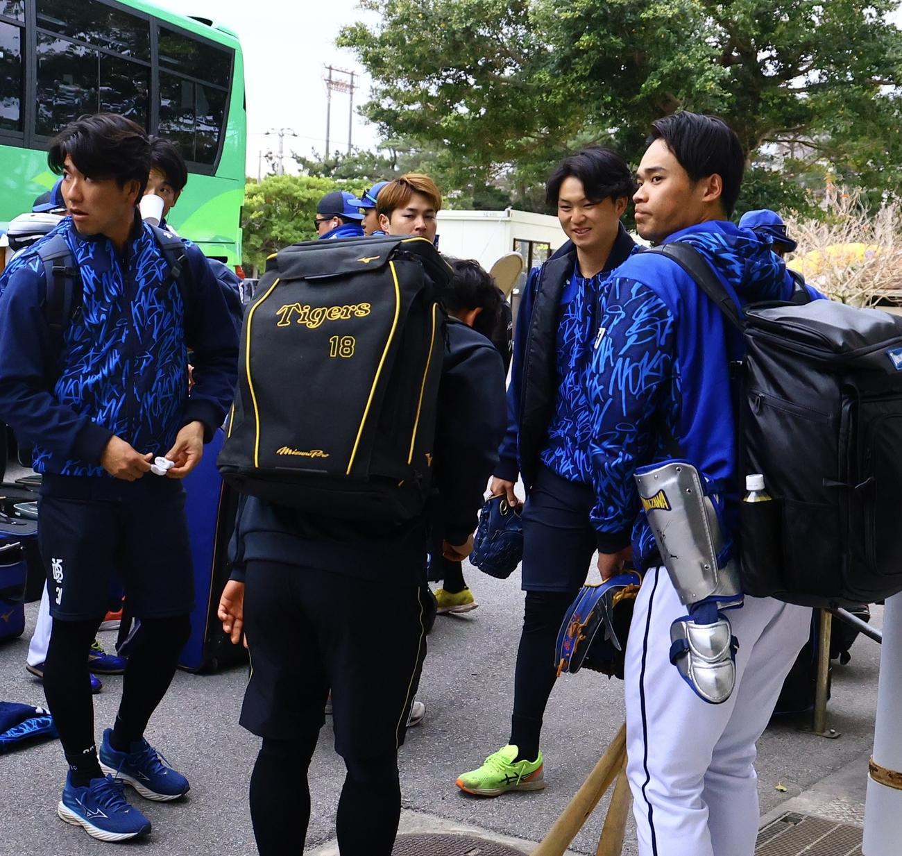 オ練習試合のため宜野座に到着したDeNA竹田（右から2人目）にあいさつする阪神伊原（撮影・藤尾明華）