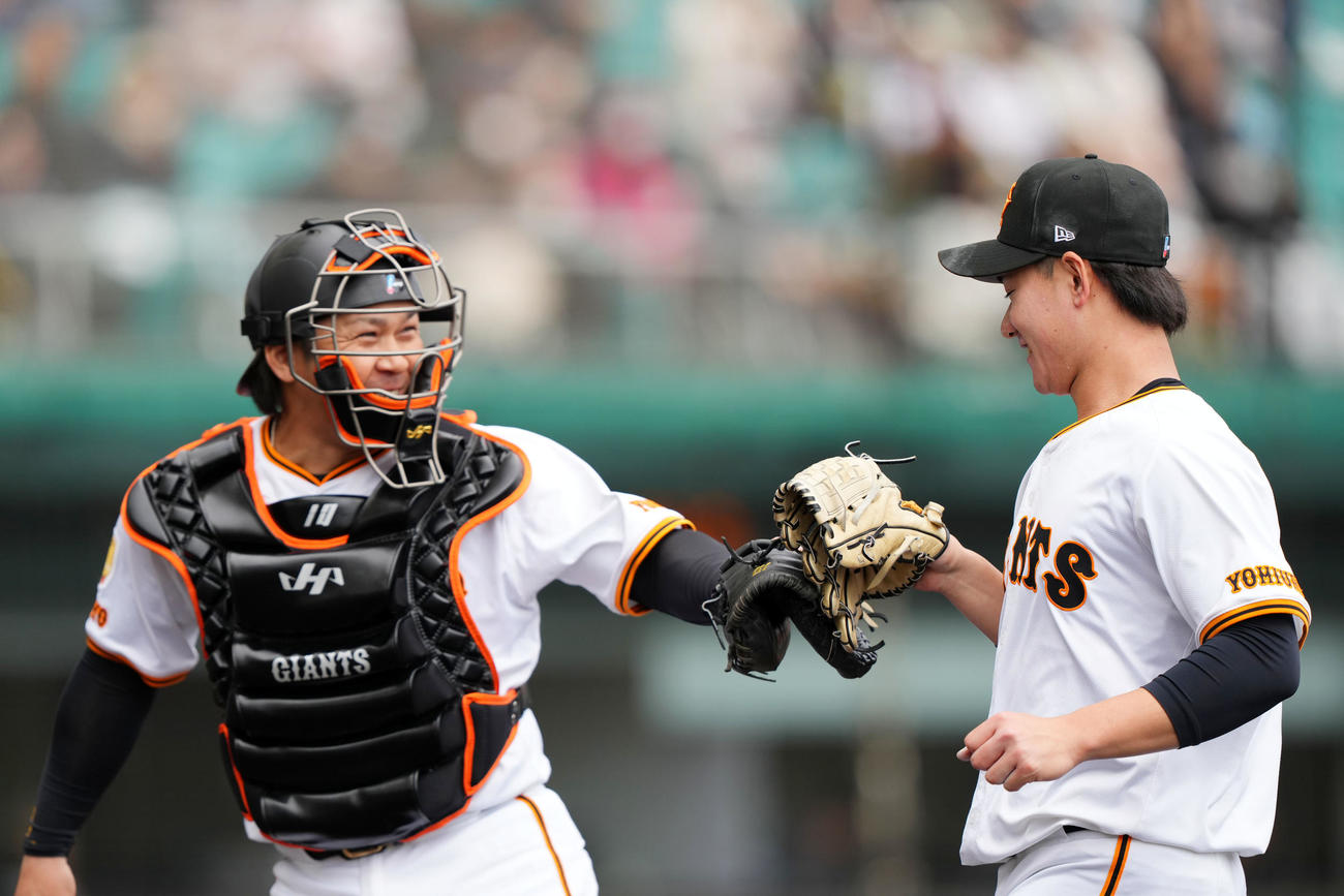 巨人対ロッテ　2回表を無失点に抑えタッチを交わす巨人井上（右）と甲斐（撮影・横山健太）