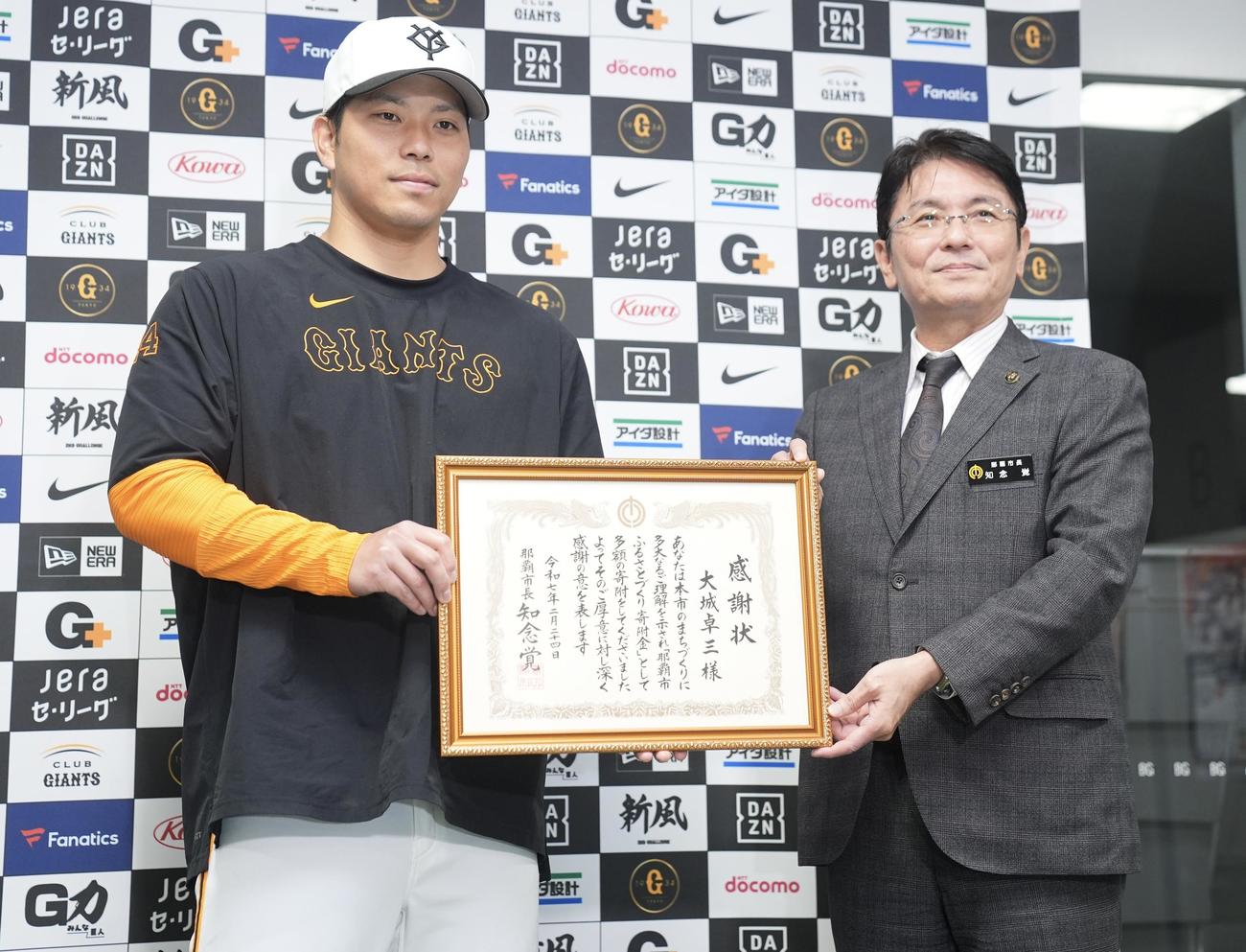 知念覚那覇市長（右）から「那覇市ふるさとづくり寄附金」への感謝状を送られる巨人大城（撮影・垰建太）