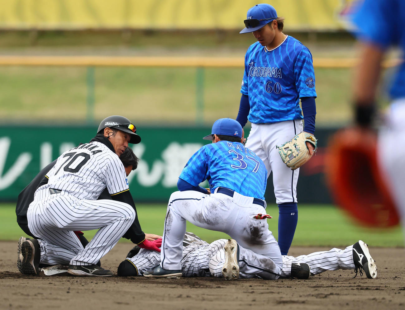 練習試合阪神対DeNA 8回裏阪神2死一塁、打者小幡のとき二盗を決めた福島は加藤と交錯し倒れ込む（撮影・藤尾明華）