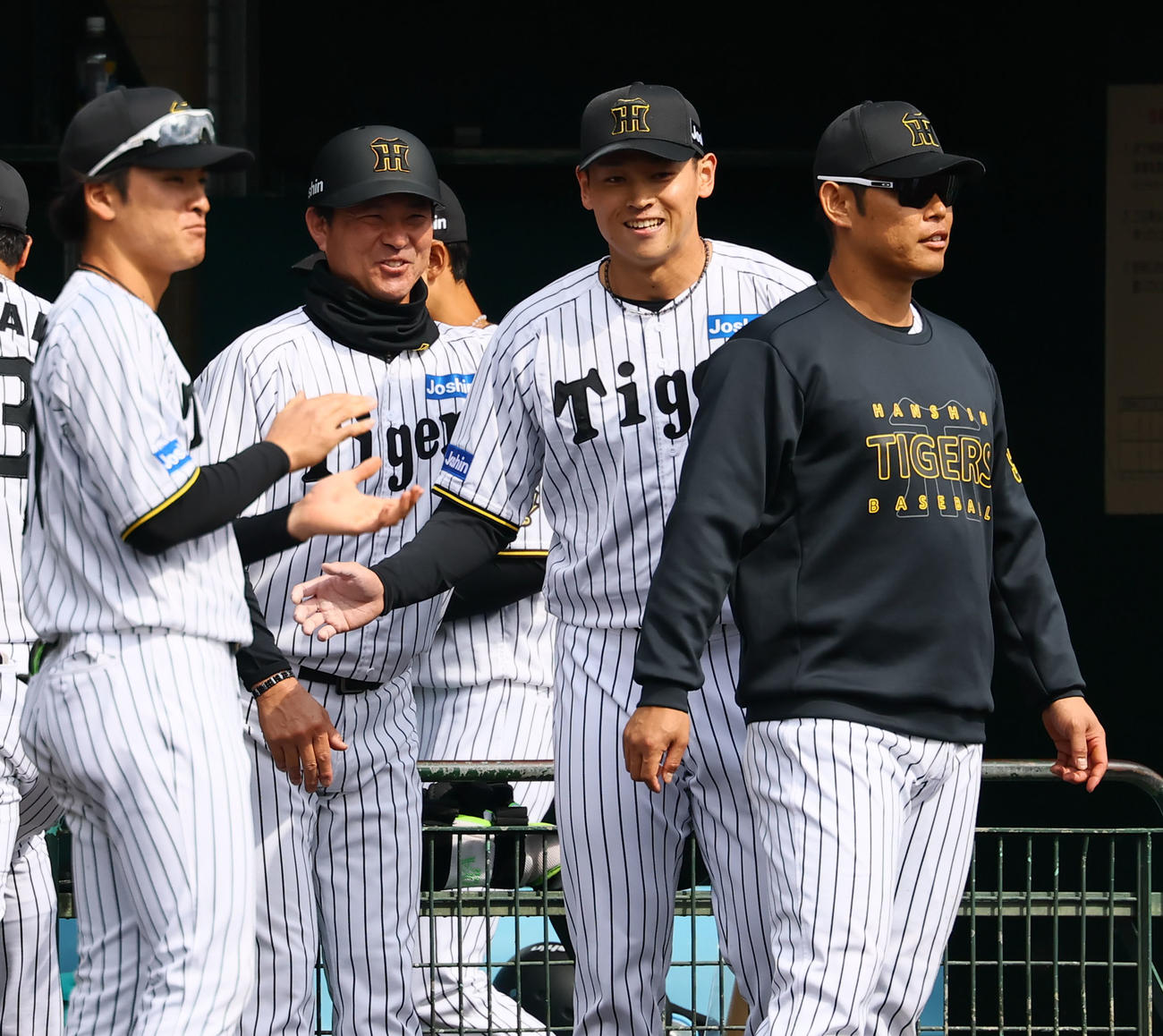 練習試合阪神対DeNA 6回、6番手で登板し笑筒井外野守備兼走塁チーフコーチ（中央左）に肩をたたかれ笑顔を見せる阪神工藤（撮影・藤尾明華）
