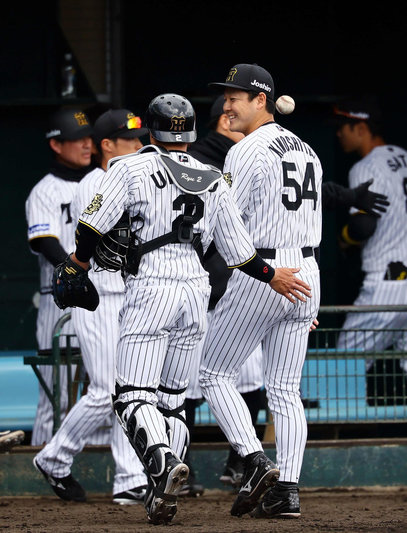 練習試合阪神対DeNA 5回、5番手で登板し無失点で終え、梅野（左）に笑顔を見せる木下（撮影・藤尾明華）
