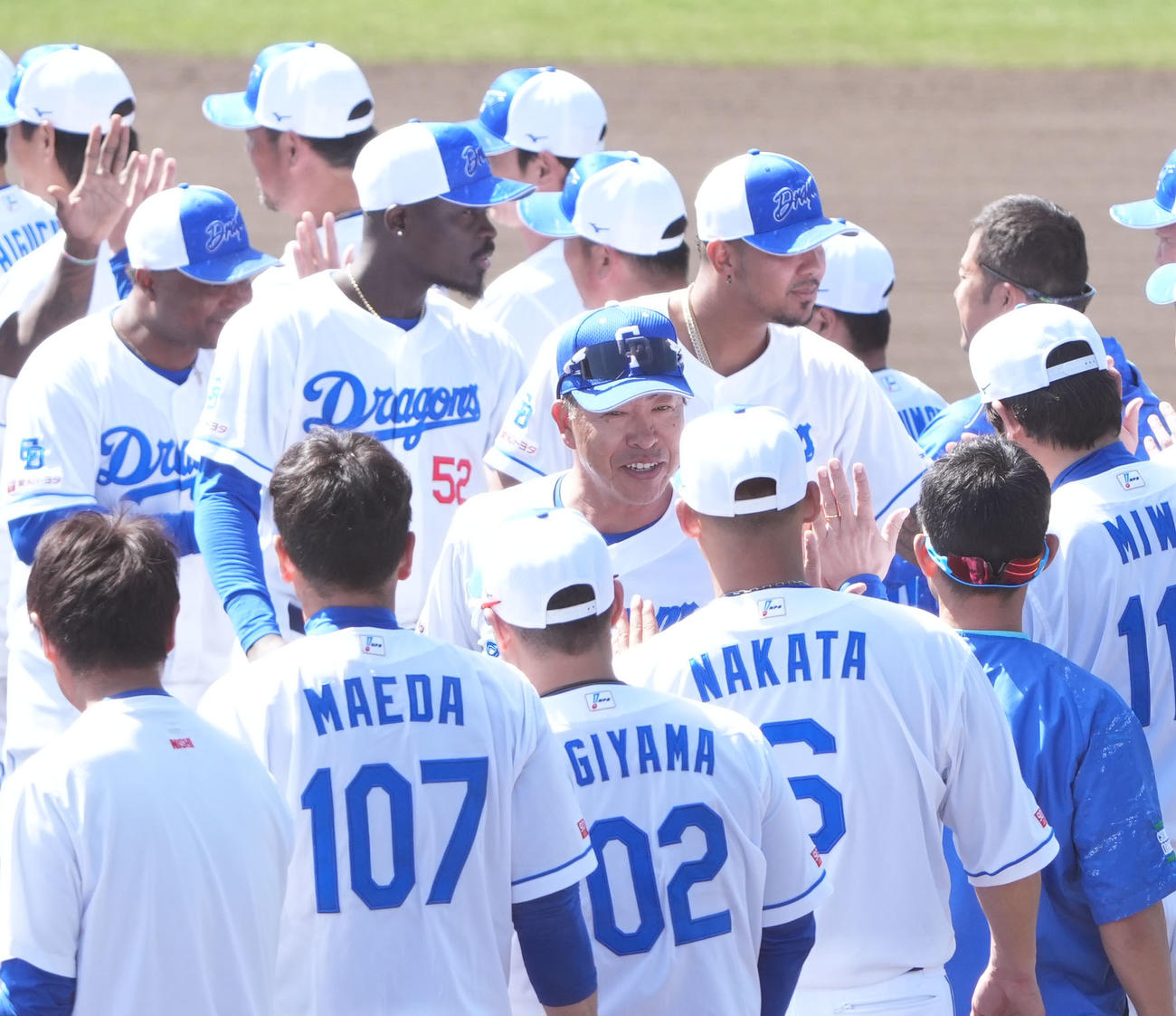 キャンプを打ち上げ、ナインとタッチを交わす井上監督（中央）（撮影・森本幸一）