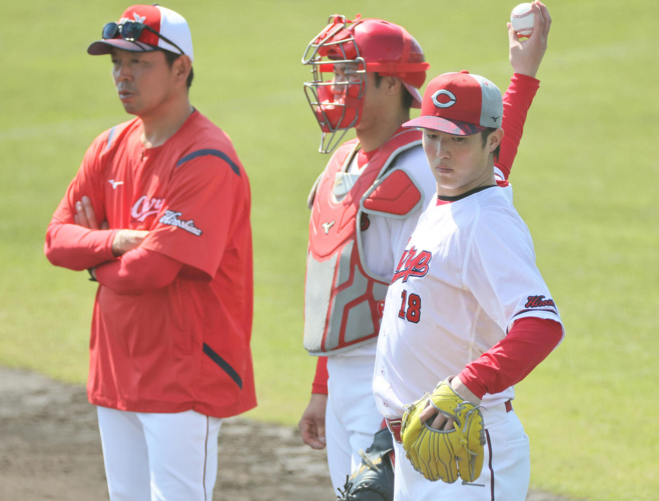 シート打撃中、坂倉と話し合う森下（右）。左は石原コーチ（撮影・加藤孝規）