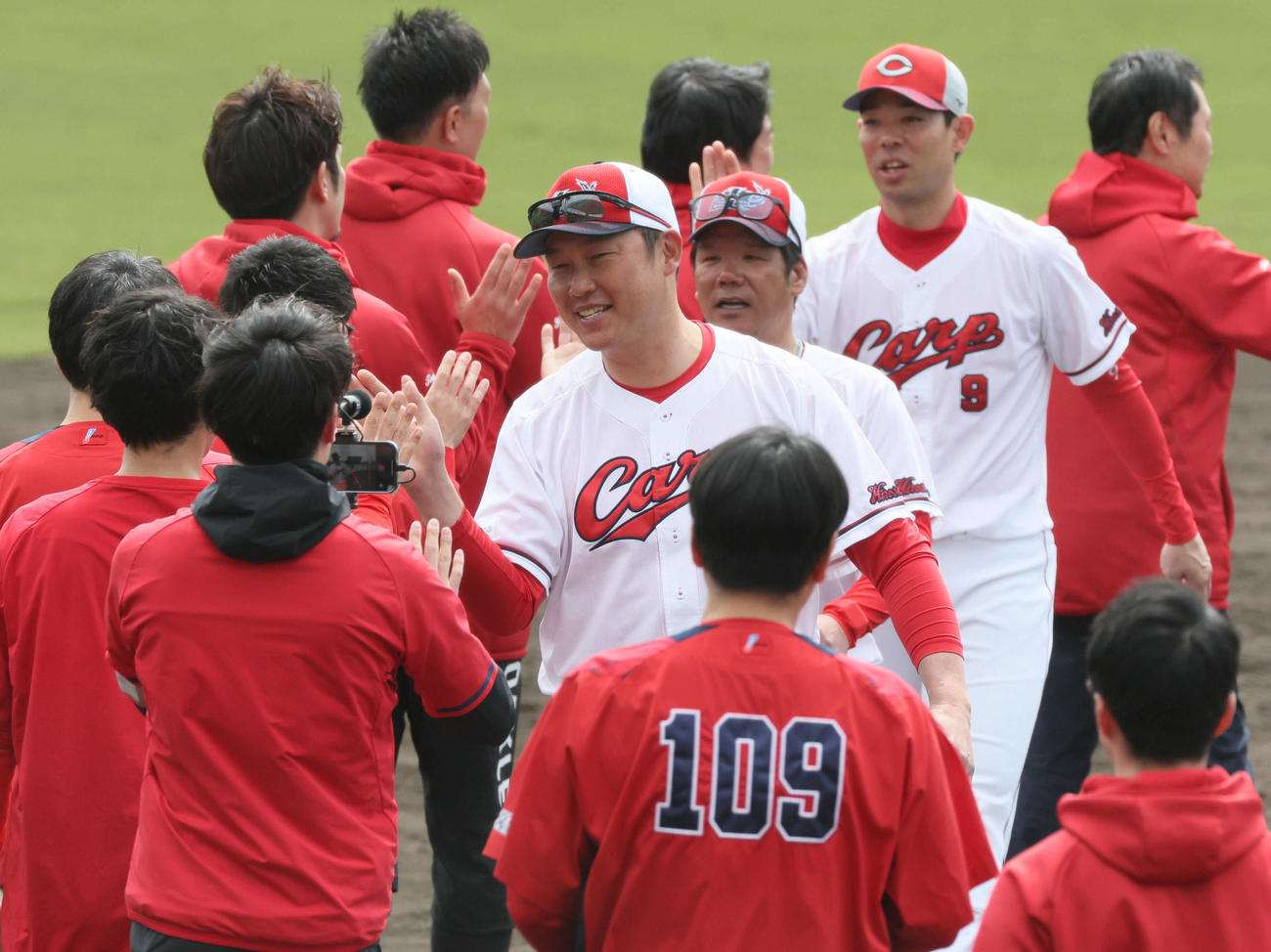打ち上げのハイタッチをする広島新井監督（中央）（撮影・加藤孝規）