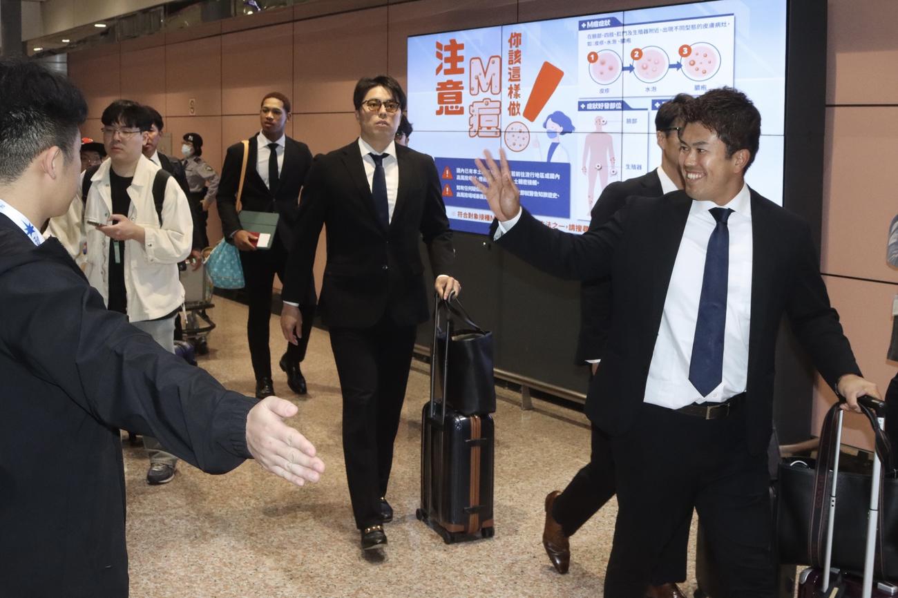 台湾に到着し笑顔を見せる日本ハム今川（右）＝2025年2月27日