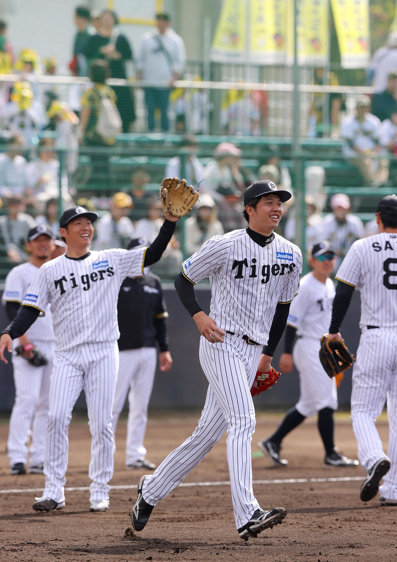 阪神才木（手前）は投内連係でリラックスした表情を見せる。左は西勇（撮影・上山淳一）