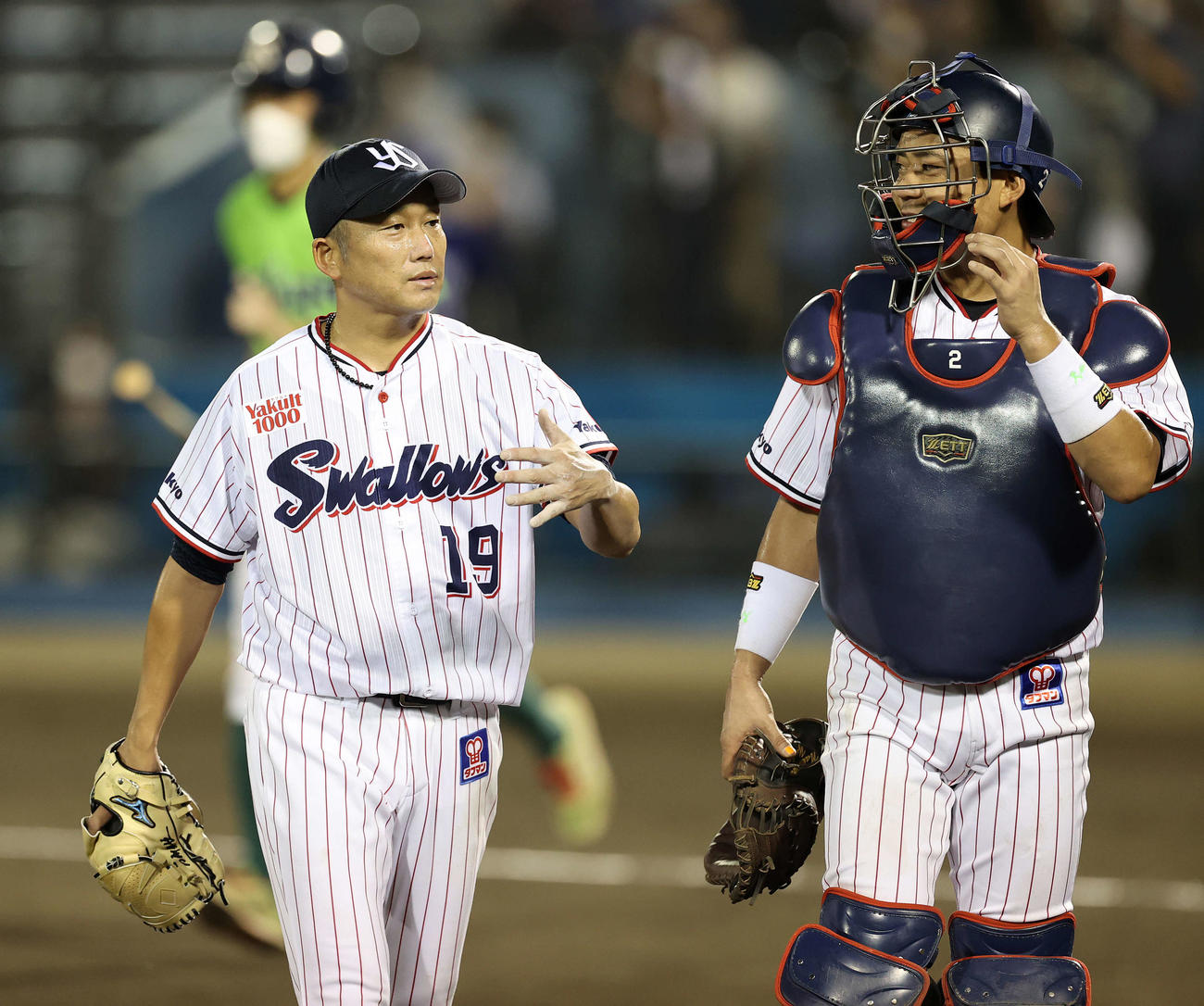 中村悠平（右）と話しながらベンチに引き揚げるヤクルト石川雅規（2021年8月25日撮影）