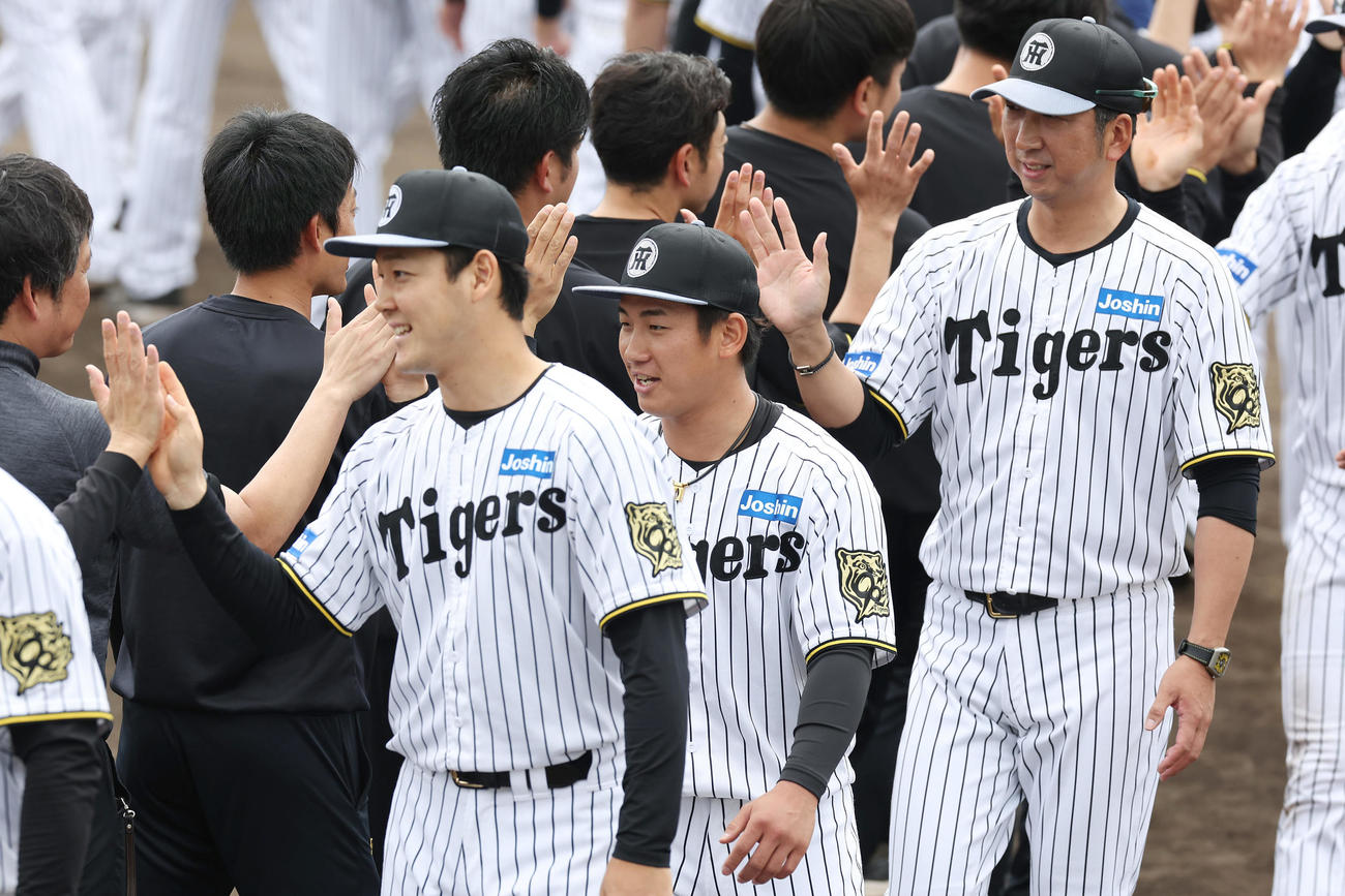 春季キャンプを打ち上げスタッフらとタッチを交わす、手前左から阪神木下、伊原、藤川監督（撮影・前田充）
