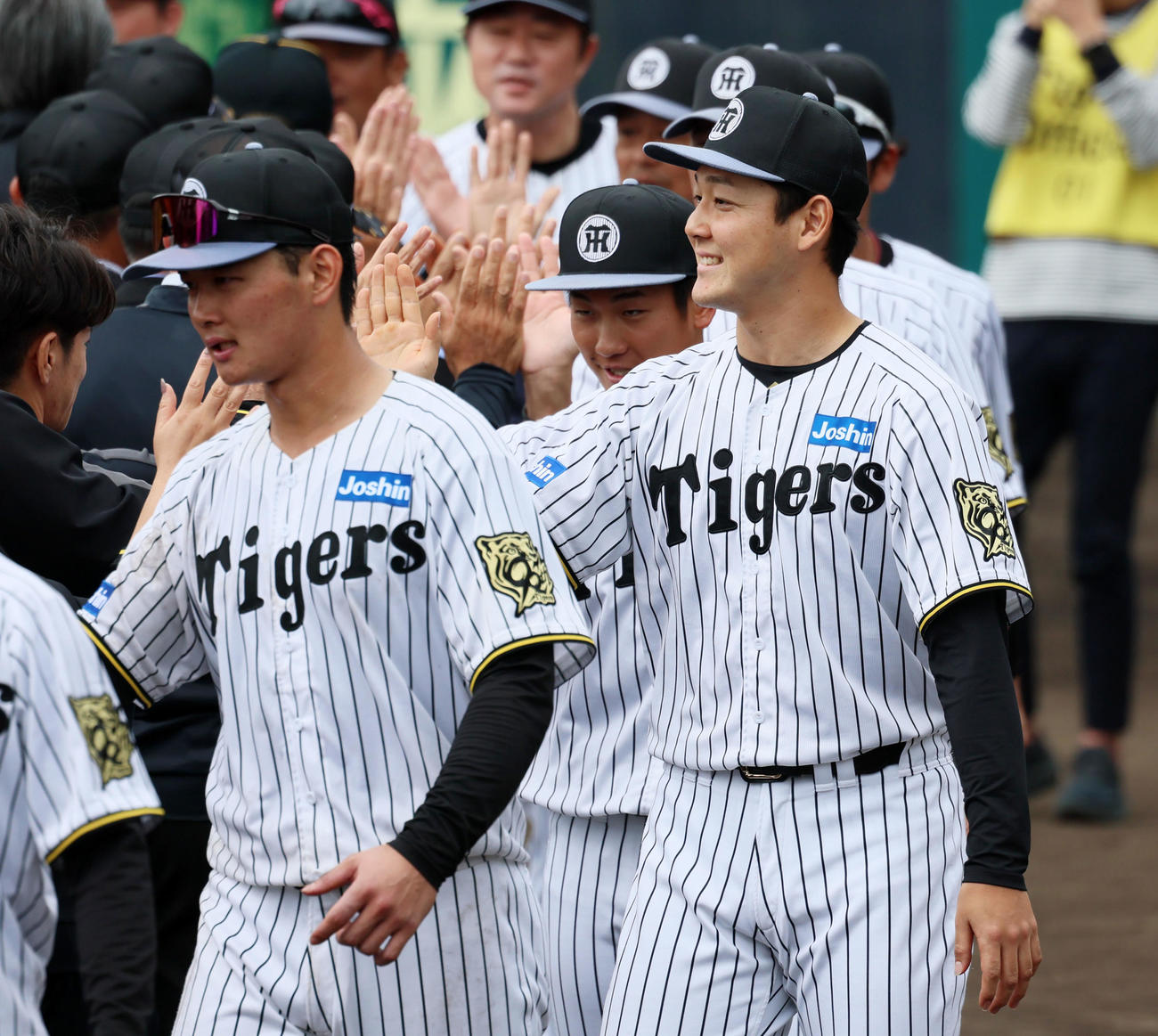 宜野座キャンプを終え関係者とタッチする左から町田、伊原、木下（撮影・加藤哉）